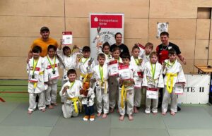 Trainerin und Übungsleiter stehen hinter den kleinen Judoka des FSv Magdeburg